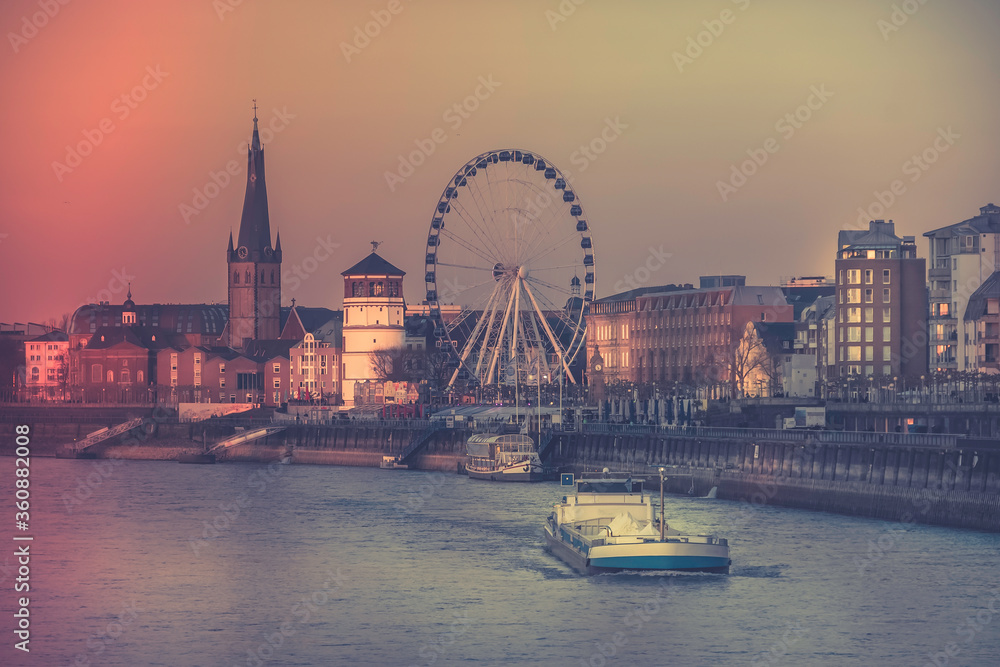 Dusseldorf, Germany - Evening Sunset View of the Boat on Rhine River and the Old Town of Dusseldorf, Germany