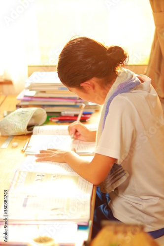 Fototapeta Naklejka Na Ścianę i Meble -  家の机で宿題を一生懸命勉強している子供の横顔