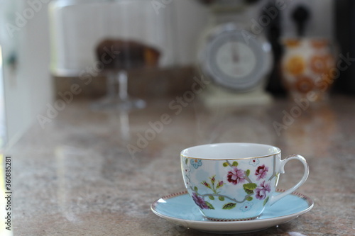English blue and white tea cup on saucer in fine china with delicate flowers and gold edging