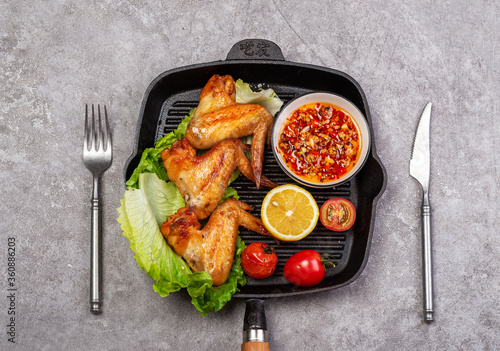 Delicious grilled chicken wings and vegetable salad