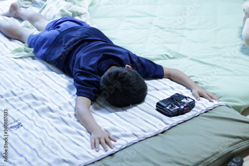 夏バテのため布団でダラダラしている小学生の床の子
