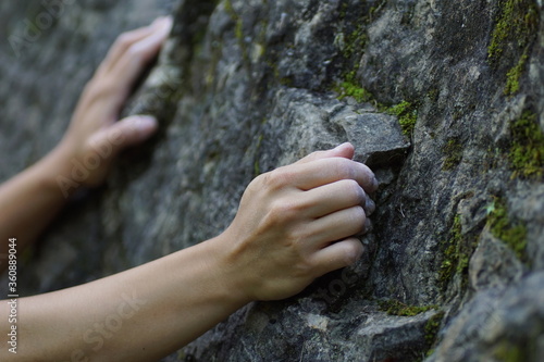 Girls hands grabbing a rock while climbing