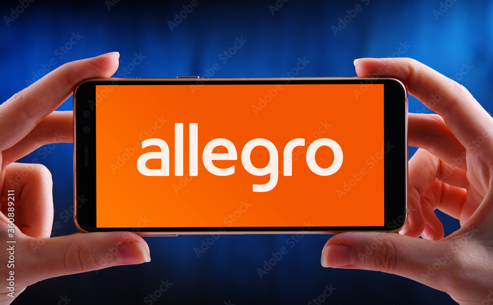 Hands holding smartphone displaying logo of Allegro Stock-Foto | Adobe Stock
