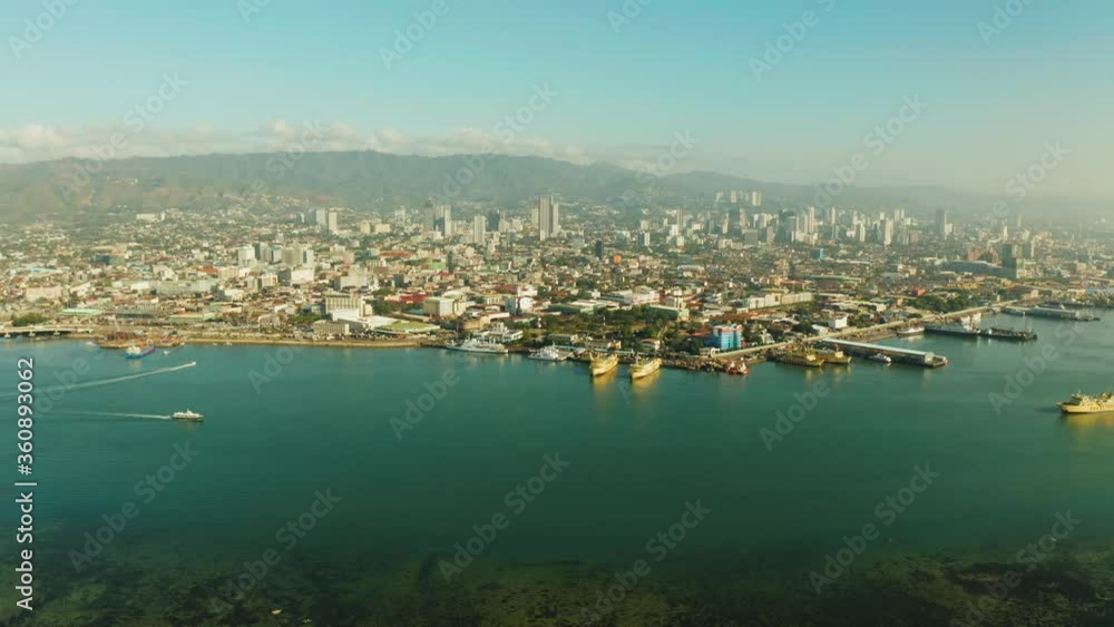 Aerial view of panorama of Cebu city with skyscraper, buildings and seaport with ships and ferries in the early morning. Philippines. Aerial view of panorama of Cebu city with skyscraper, buildings and seaport with ships and ferries in the early morning. Philippines.