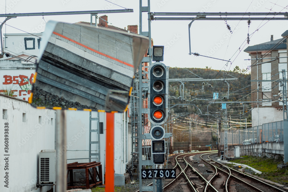 Naklejka premium Mirror at railway station with voltage lines and tracks in the background