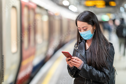 Photography Chinese woman wearing face mask at underground train station and keeping social