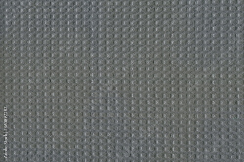 Grunge texture of a gray cotton towel in small squares. Texture of natural soft fabric. Rough matting.