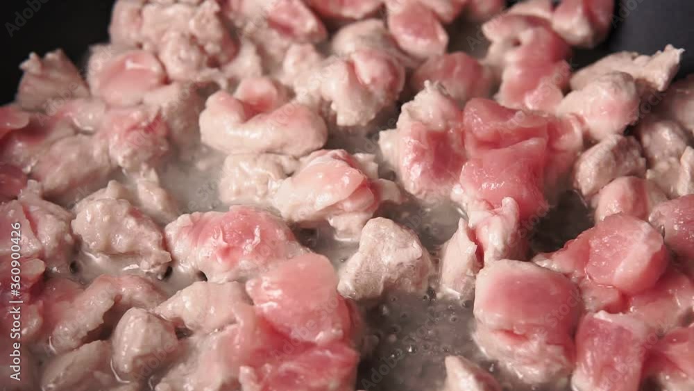 fried pieces of pork meat in a frying pan fried pieces of pork meat in a frying pan