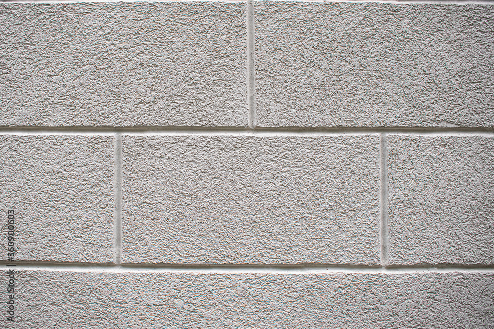 Fototapeta premium Texture of rough gray stucco wall. The walls are covered with cement decorative plaster. Large blocks covered with decorative stucco. Background for website, design.