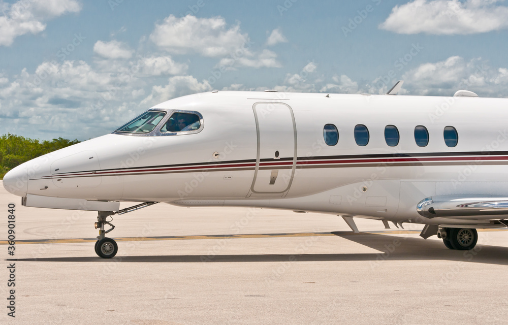 view, far distance, of an executive, private jet, aircraft, taxiing to runway, before taking off, on tropical, island, airstrip, on the gulf of Mexico, on a sunny afternoon