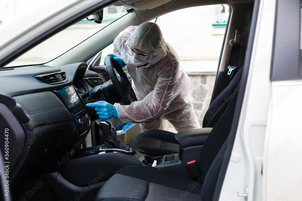 Disinfectant worker character in protective mask and suit sprays bacterial or virus in a car.