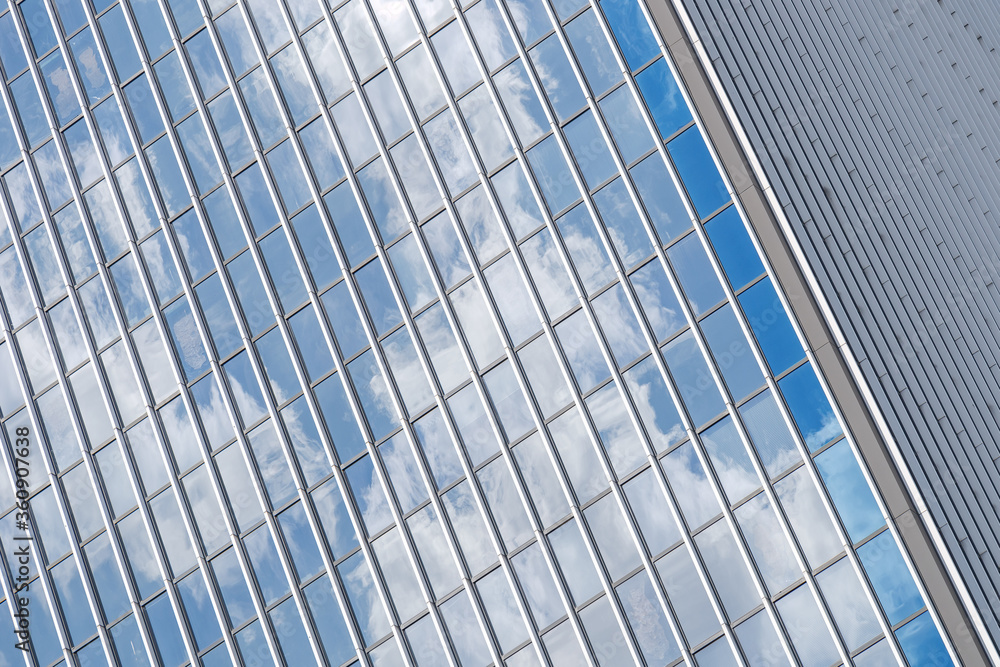 Close up detail of reflected glass facade with rectangular windows grid frame system of modern office building. Abstract Architectural Geometry elements background with urban metropolis concept. Close up detail of reflected glass facade with rectangular windows grid frame system of modern office building. Abstract Architectural Geometry elements background with urban metropolis concept.