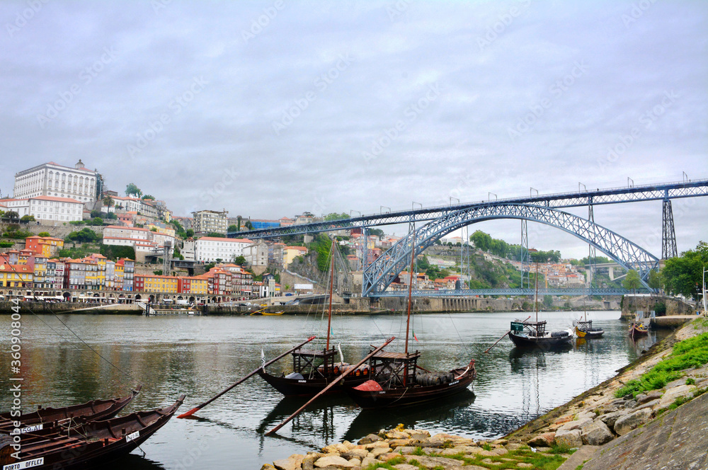 Ships with barrels of wine on the Duoro River in Porto with a view on Eiffel's bridge.
