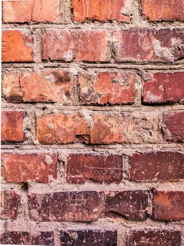  The texture of red antique brick. Background of old red brick wall texture with deterioration from age. The brick wall is lit by the bright sun.