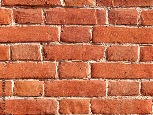 The texture of red antique brick. Background of old red brick wall texture with deterioration from age. The brick wall is lit by the bright sun.