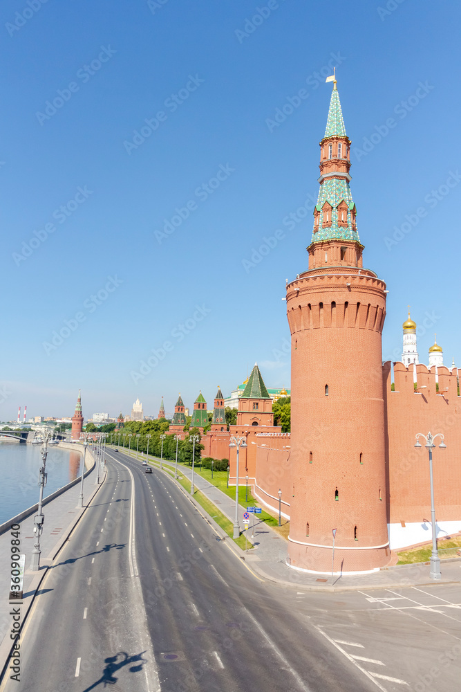 Cityscape of Moscow city near Moscow Kremlin made from red bricks with green trees and few orthodox churches on a summer morning. Clear blue sky. Theme of travel in Russia.