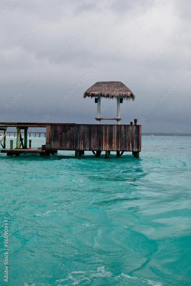 Maldivian water pavillion and jetty seen from turquoise ocean