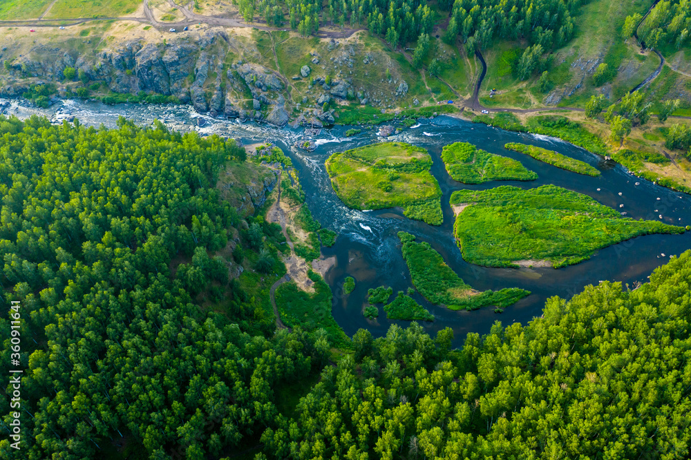 beautiful view vertically down from a great height on beautiful valley with forest and rocks, the mountain river is divided into several streams and Islands. Ural, the threshold Revun.
