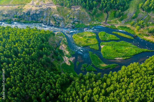 beautiful view vertically down from a great height on beautiful valley with forest and rocks, the mountain river is divided into several streams and Islands. Ural, the threshold Revun.