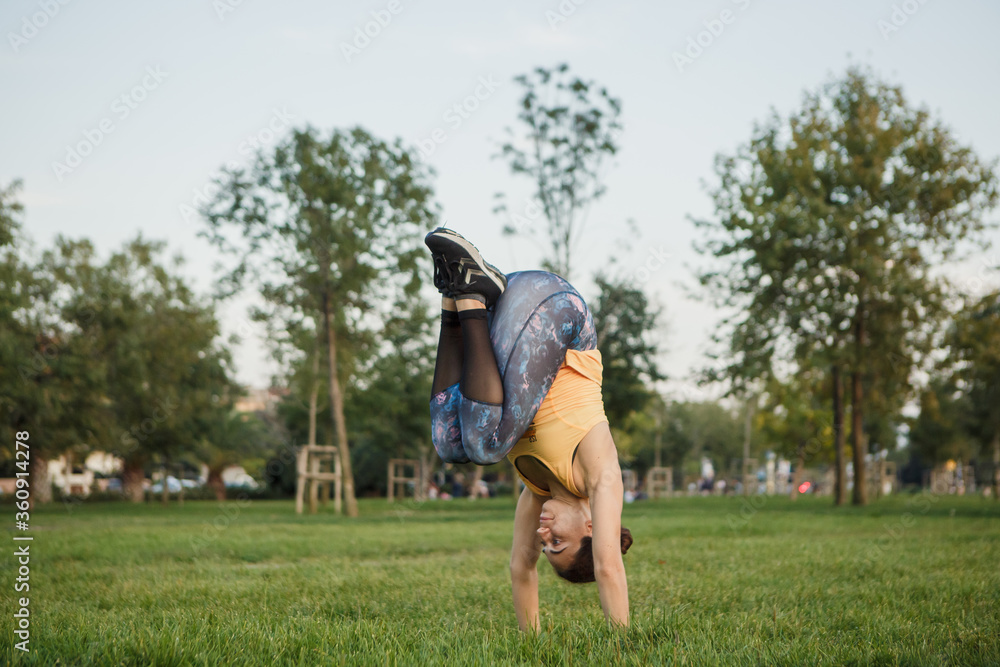 fit woman doing stretching exercises on the grass before starting sports. woman doing plates on the grass.