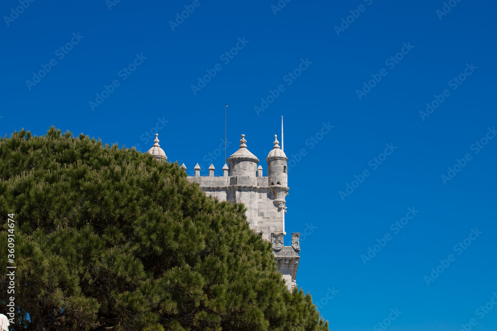 Belém Tower and Tagus River in the blue background and trees as a frame, Lisbon, Portugal