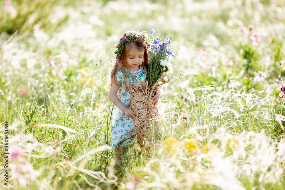 portrait of a cute little girl with a wreath on her head smiling holding wildflowers of cornflower portrait of a cute little girl with a wreath on her head smiling holding wildflowers of cornflower