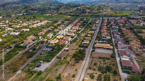 Aerial view of the Villa in Campofelice di Roccella in Sicily, under a beautiful sunny sky, with swimming pools and trees.