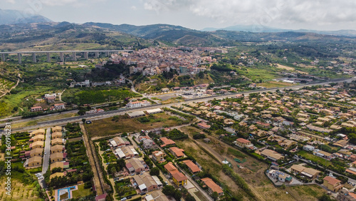 Aerial view of the Villa in Campofelice di Roccella in Sicily, under a beautiful sunny sky, with swimming pools and trees.