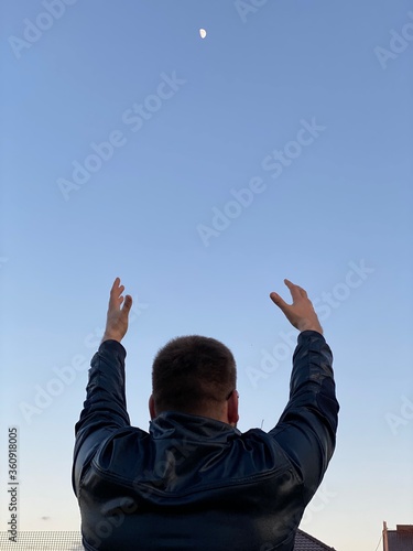 a young man raises his hands up to the sky, raise his hands, I want to go to the sky