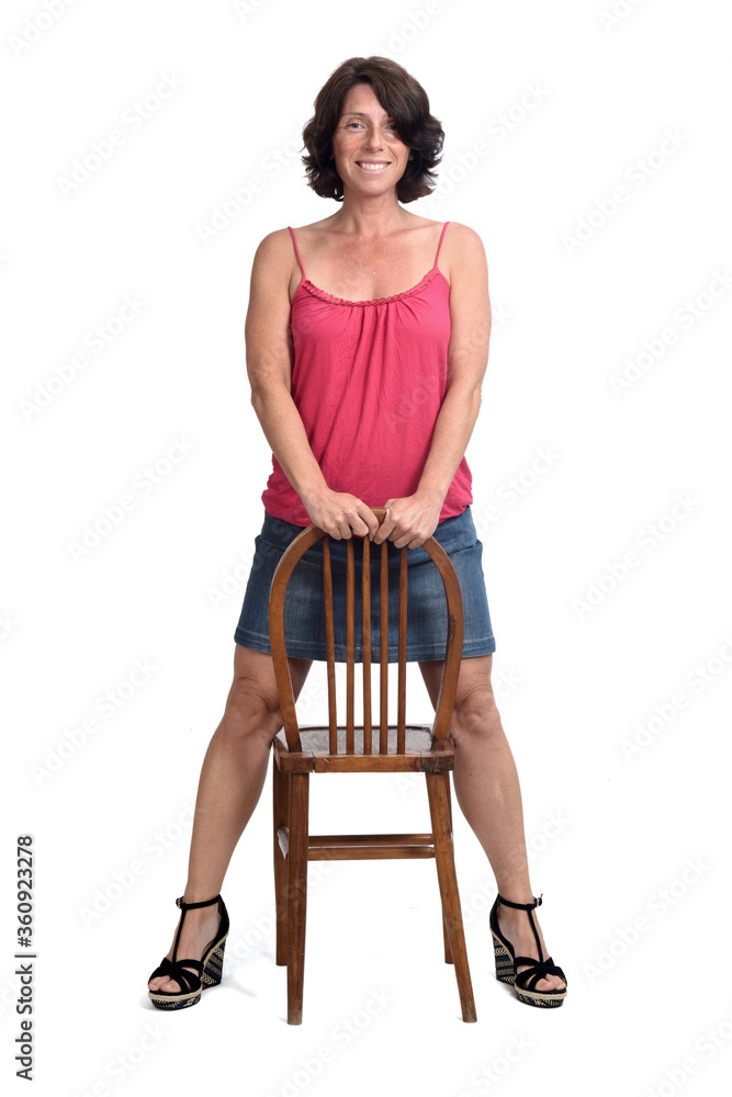  woman in denim skirt playing with a chair on white background,