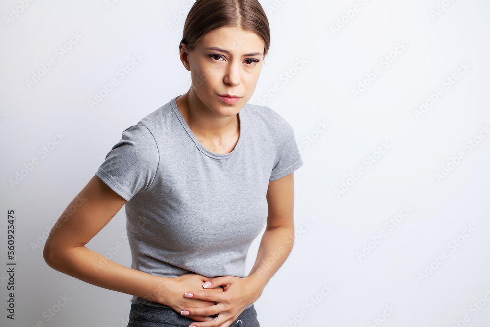 Obraz premium Exhausted young woman suffering from severe abdominal pain