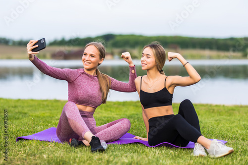 Fototapeta Naklejka Na Ścianę i Meble -  Beautiful girls taking a selfie with a smart phone after going for a run outdoors