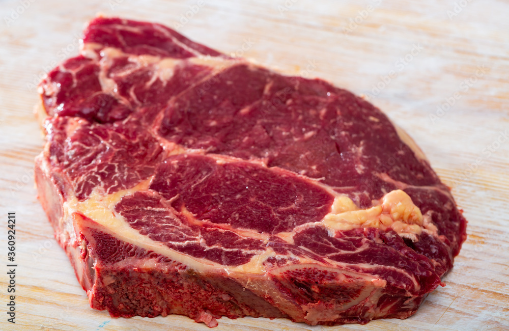 Fresh chop of beef on natural wooden background, nobody