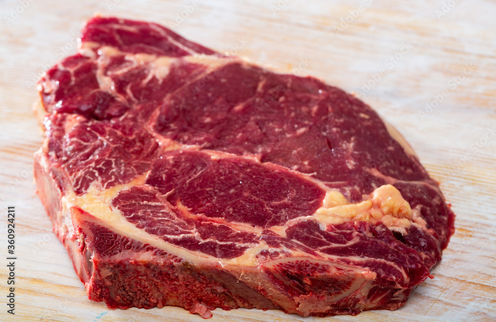 Obraz premium Fresh chop of beef on natural wooden background, nobody