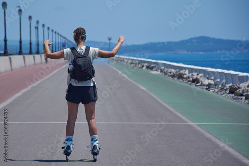 chica joven haciendo deporte con sus patines en linea y su mochila