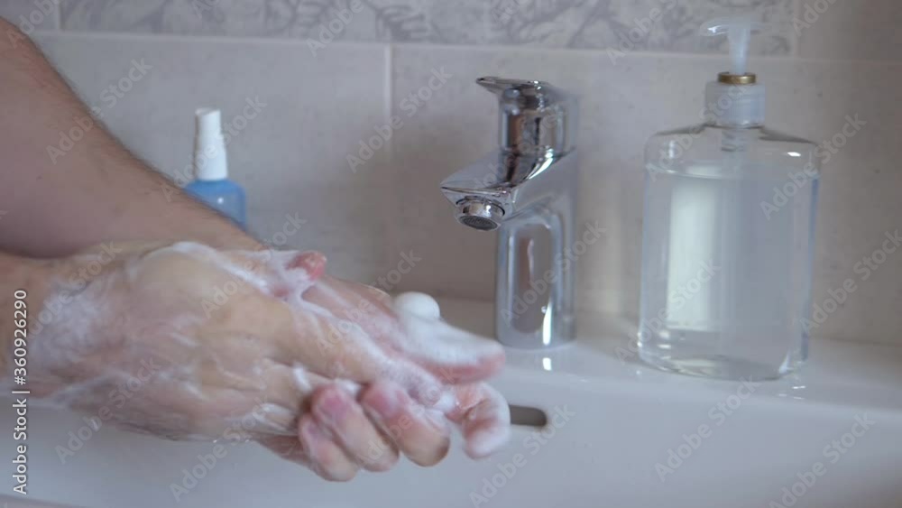 SLOW MOTION: Hands are lathered with soap and washed water.Coronavirus Pandemic Prevention. Correct way to wash hands. Close-up of Caucasian man washing his hands with soap. SLOW MOTION: Hands are lathered with soap and washed water.Coronavirus Pandemic Prevention. Correct way to wash hands. Close-up of Caucasian man washing his hands with soap.
