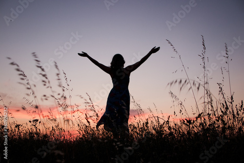 free woman rising arms in sunset