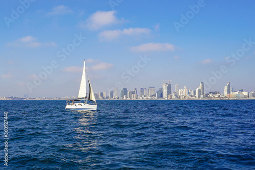 Sailing yacht on the background of the coastline of the city of Tel Aviv. Concept of water tourism. Sailing a yacht.