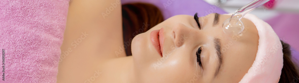 Darsonvalization of the face or rejuvenation of the face with the help of electrotherapy. Photo of darsonval for the face. Current therapy. The patient is at the beautician. Darsonvalization of the face or rejuvenation of the face with the help of electrotherapy. Photo of darsonval for the face. Current therapy. The patient is at the beautician.