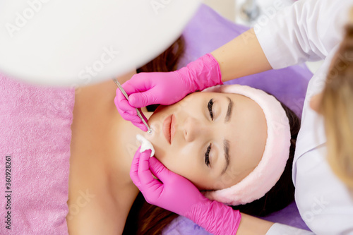 Cosmetologist at spa beauty salon doing acne treatment using mechanical instrument. Concept of medical treatment of rejuvenation and skincare.