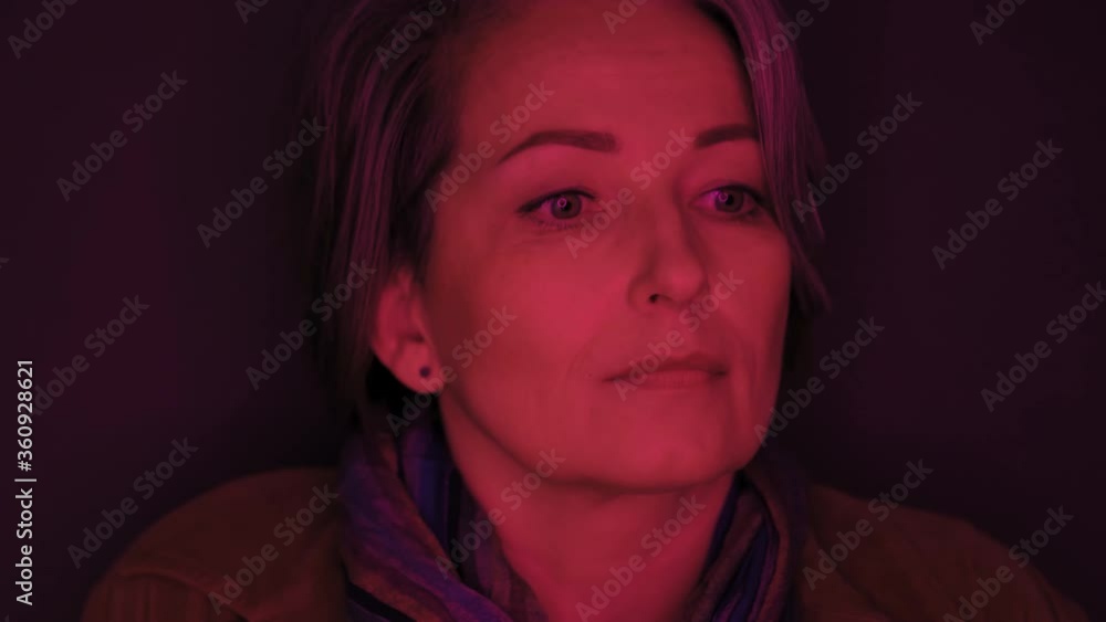 Frustrated mature woman in casual clothes smiles looking at camera. Portrait of Caucasian lady in brown fustian jacket and colorful scarf on gray background. Red tone footage. Prores 422. Frustrated mature woman in casual clothes smiles looking at camera. Portrait of Caucasian lady in brown fustian jacket and colorful scarf on gray background. Red tone footage. Prores 422.