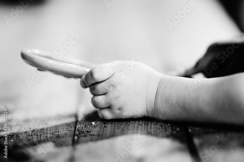 Chubby baby or little boys hand holding a toy mobile phone. Black and white photo © SteinOve