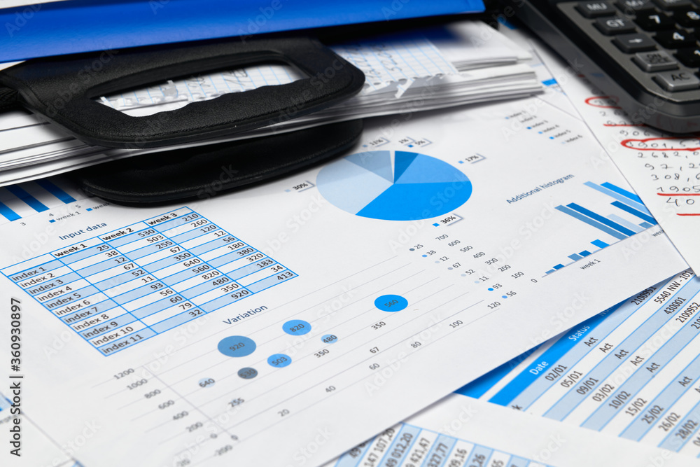 business office desk closeup - financial reports, analysis and accounting, set of documents, tables and graphs, various items for bookkeeping, calculator business office desk closeup - financial reports, analysis and accounting, set of documents, tables and graphs, various items for bookkeeping, calculator