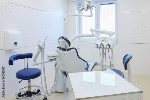 A modern interior of a dental office with white and blue furniture  dental chair. Dentist   s office. Dental laboratory.