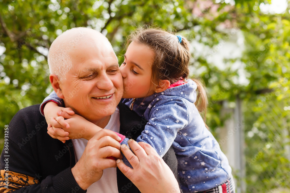 Fototapeta premium Funny lifestyle portrait of grandchild embracing grandfather