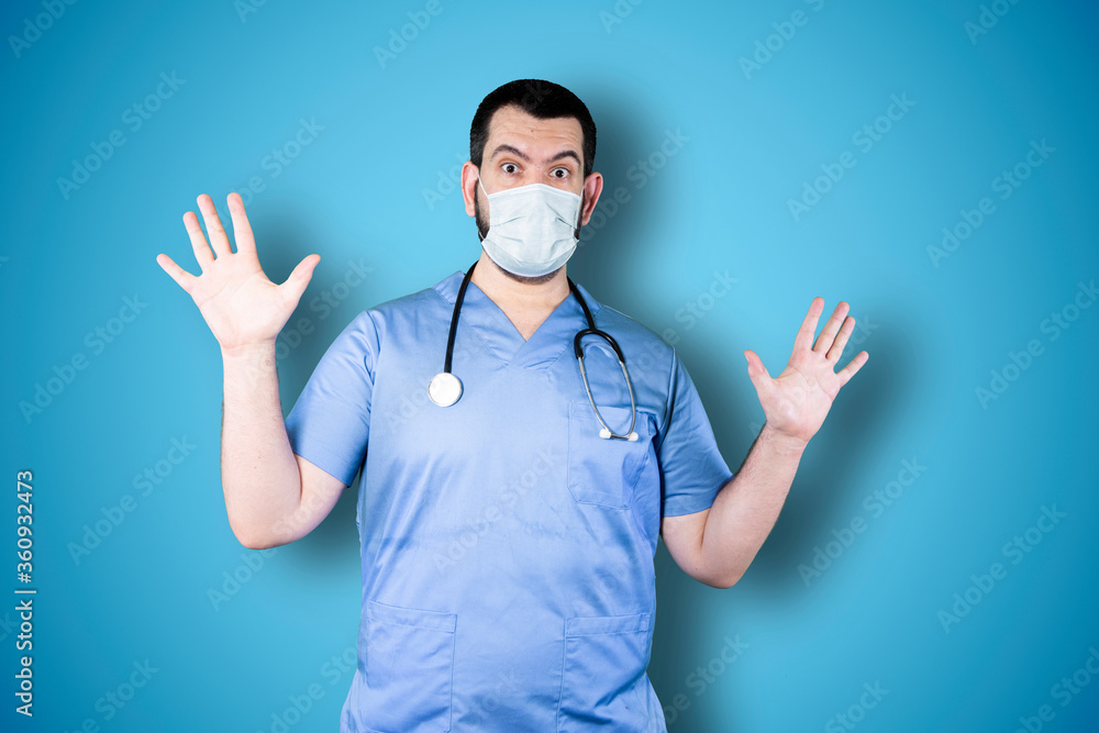 Doctor with mask over isolated blue background studio with surprise facial expression Doctor with mask over isolated blue background studio with surprise facial expression