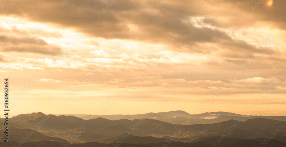 Mountains on the horizon with an orange sky during a sunset