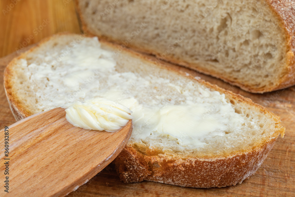 Butter spreading on fresh bread. Bread in the home kitchen.