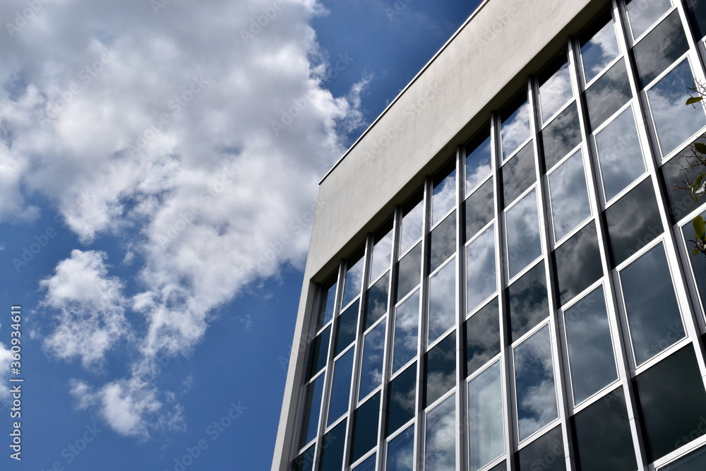 Fototapeta premium Wolken spiegeln sich in einem Bürogebäude in Basel
