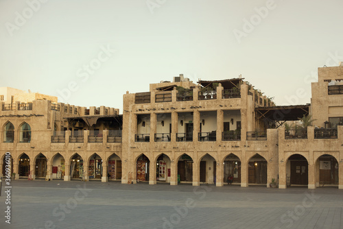 Souq Waqif during quarantine. Empty area in front of the market. Shops and cafes do not work. Sunset. Orange sky Mosque